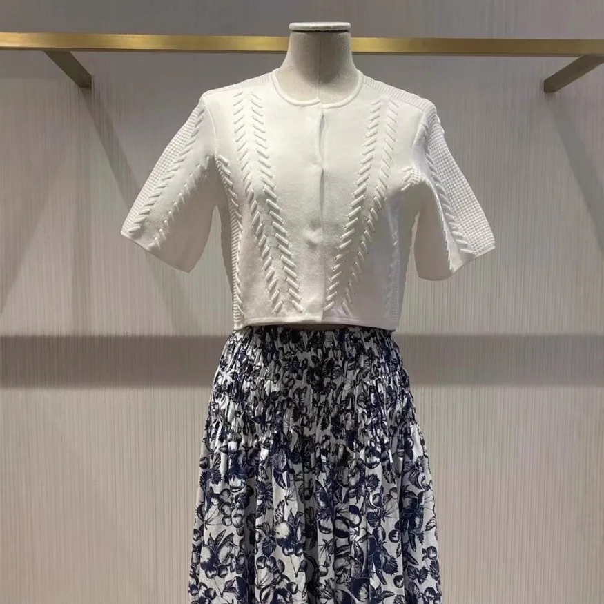 بدلة نسائية بيضاء مكونة من قطعتين، سترة بيضاء محبوكة بأكمام قصيرة أو فستان بحمالات ضيقة