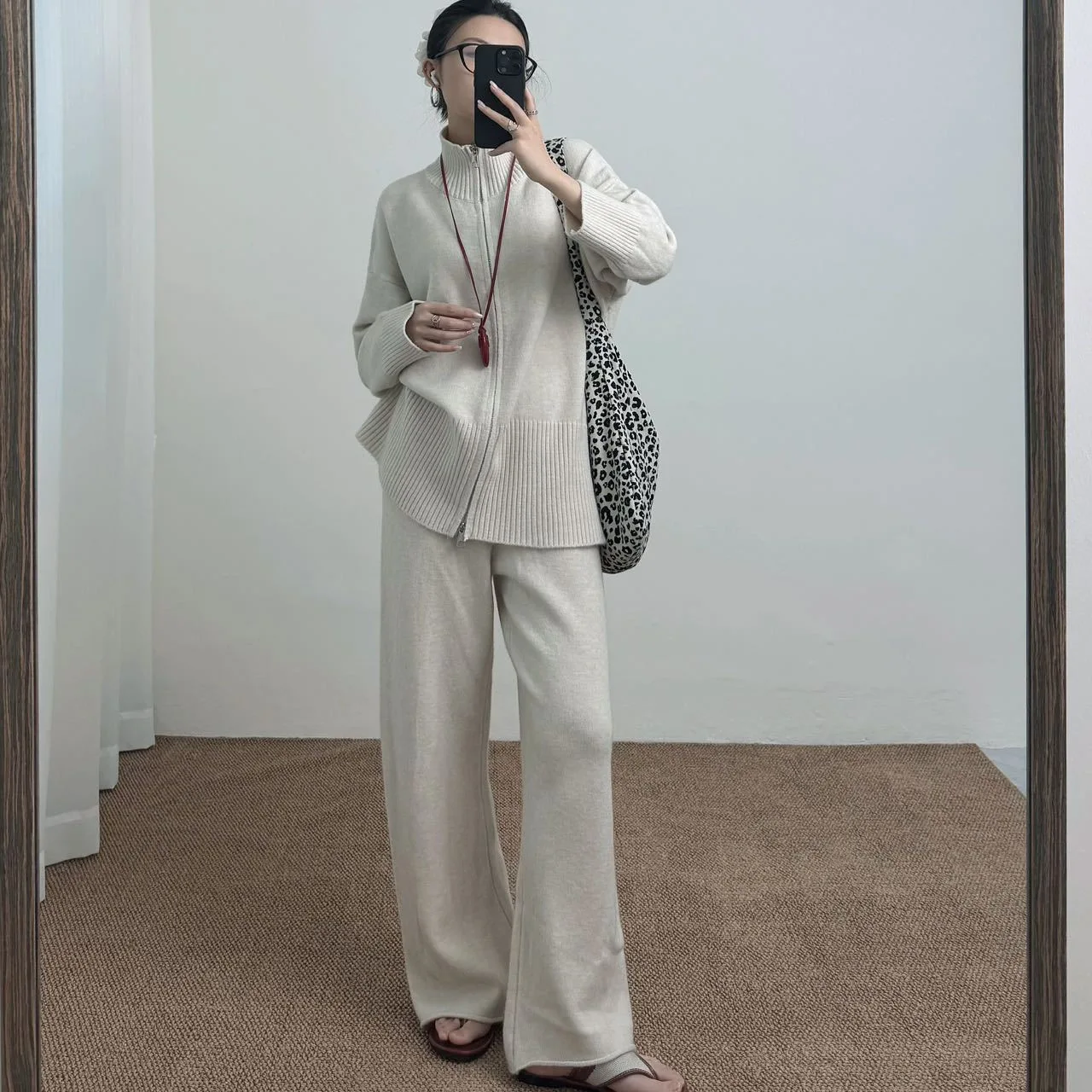 Setelan Dua Potong Kasual untuk Wanita dengan Cardigan Rajut Gaya Longgar Berwarna Solid dan Rok dengan Ritsleting Ganda.