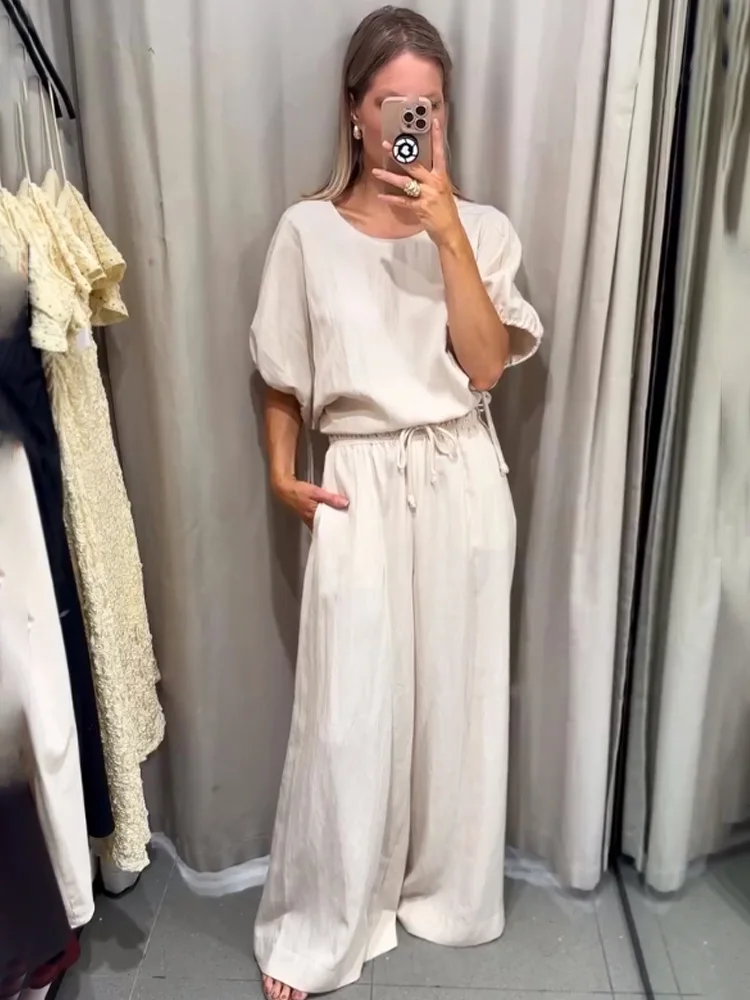 ชุดเซ็ต 2 ชิ้น เสื้อเชิ้ตแขนพอง คอทรงโอ แต่งเชือกผูกและกระดุม ผ้าเนื้อแน่น พร้อมกางเกงขายาวทรงสลิมเอวสูงผูกเชือก สไตล์ชุดนอน