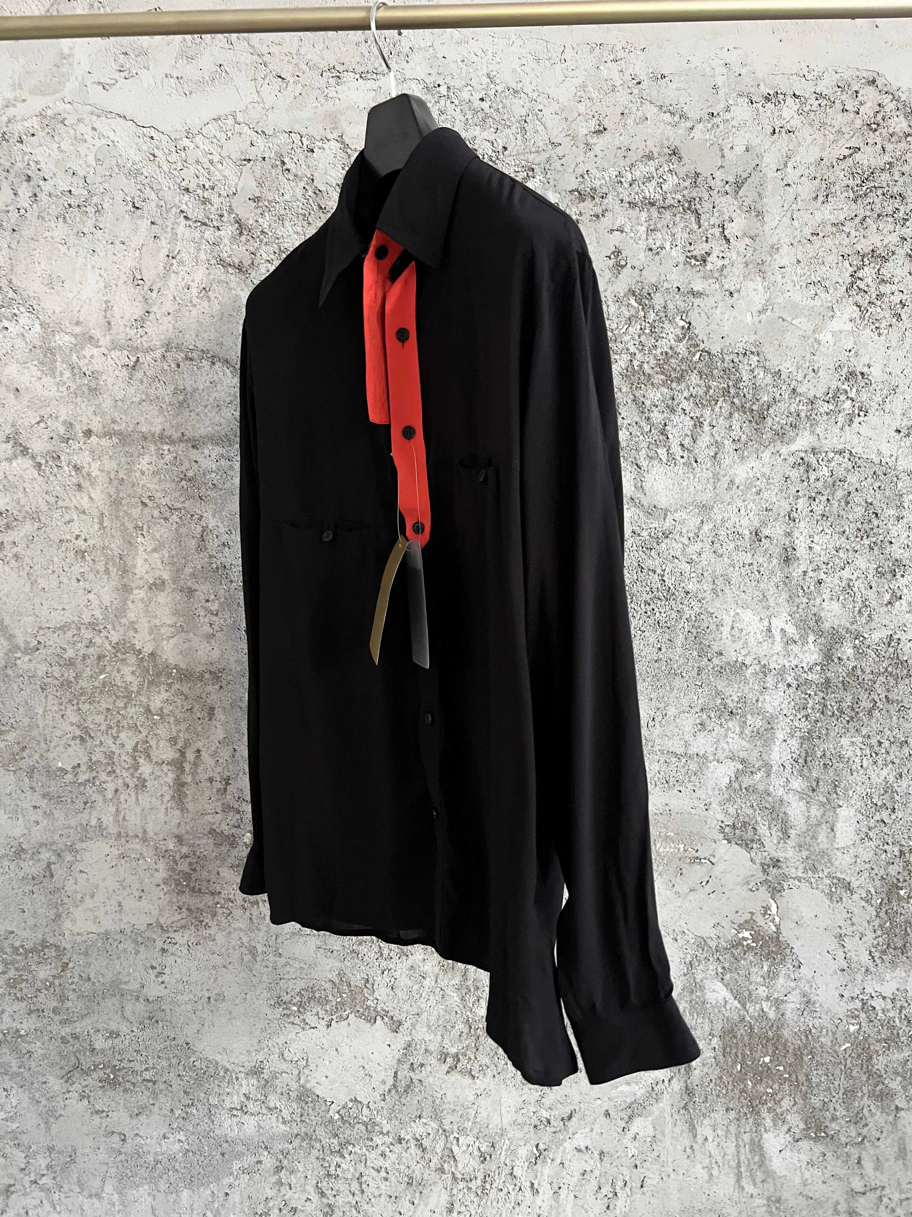 An original design of a red and black color contrast and irregular lapel shirt