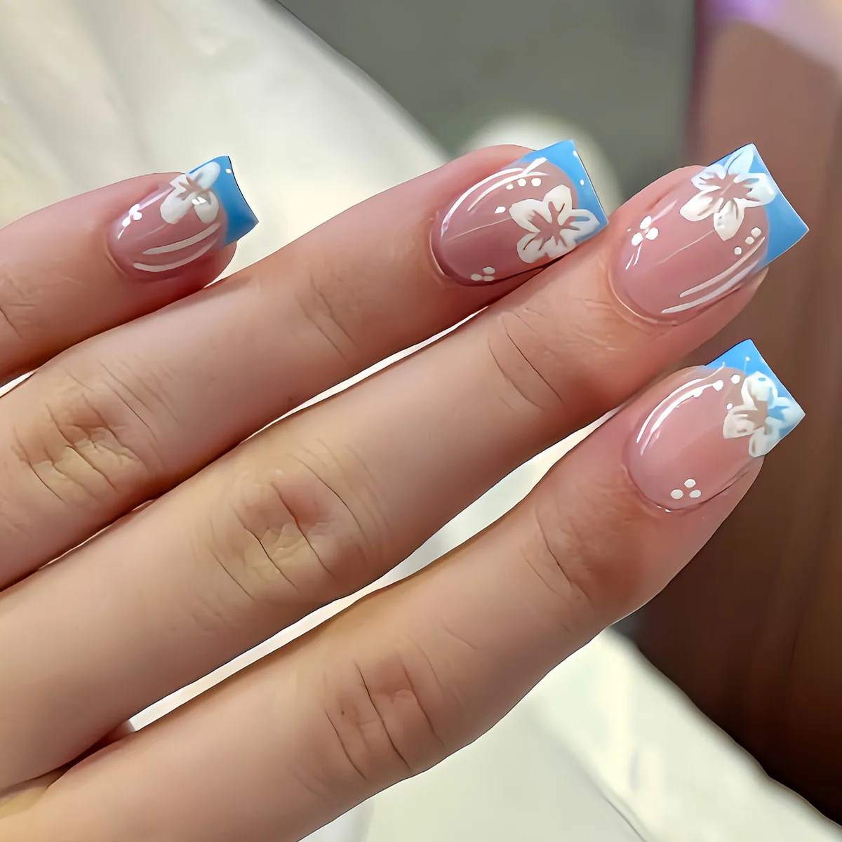 24pcs handmade short square nails. Clear nude base with light blue French tips & hand-painted white flowers. Reusable, fresh spr