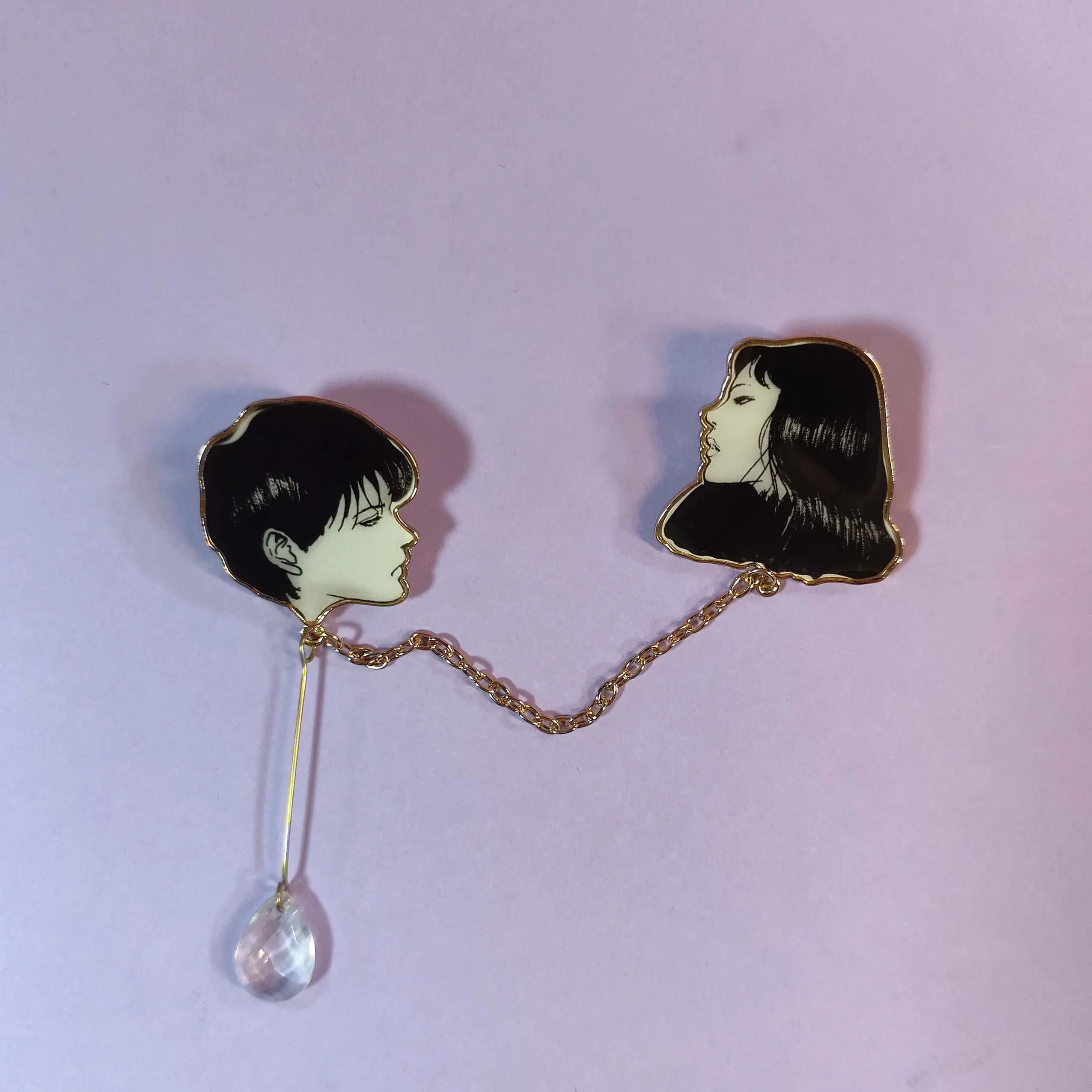 Este elegante pin esmaltado inspirado en Tomie de las obras de Junji Ito. Con un buen artesanía, muestra el encanto de Tomie.