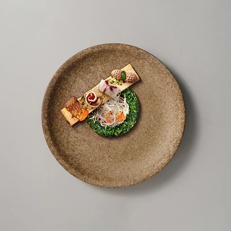 Retro-Restaurant mit mattiertem braunem, flachem Teller und runder künstlerischer Konzeption. Westliches Essen, Steak, Nudelteller, exquisites Geschirr