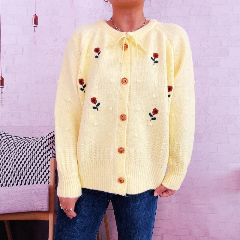 Nowy sweter-płaszcz damski na jesień/zimę 2025, z haftowanymi kwiatami, kokardą i zapinany na jeden guzik.