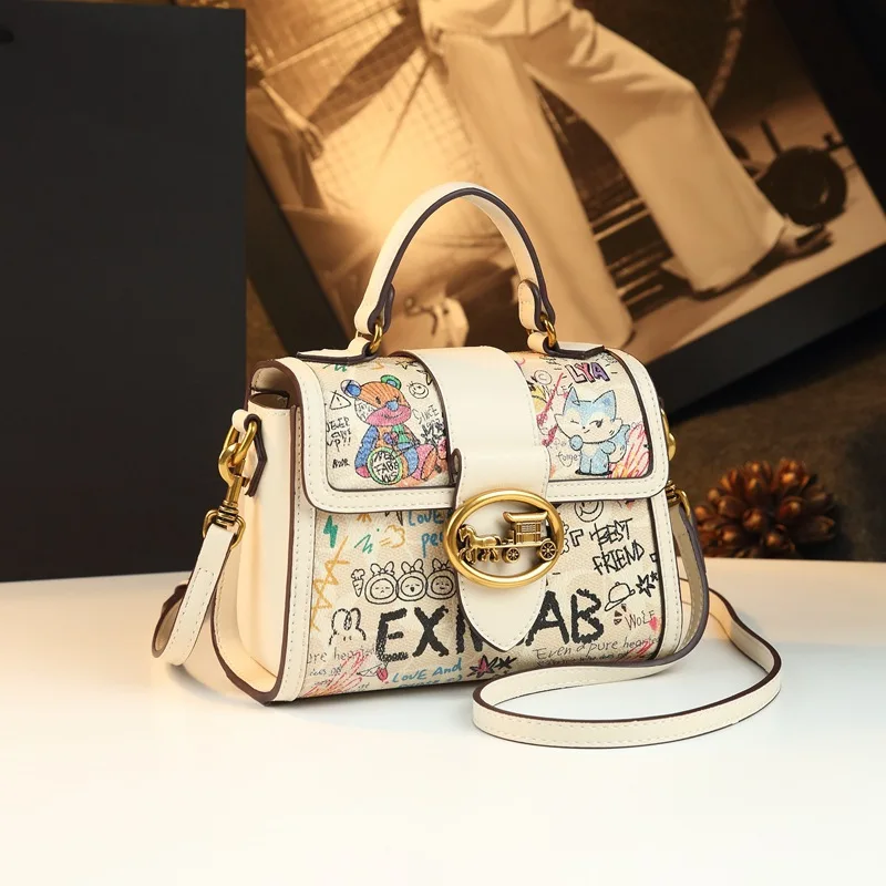 Graffiti cartoon print small handbag with vintage carriage lock and contrasting color flap, and youthful shoulder/crossbod