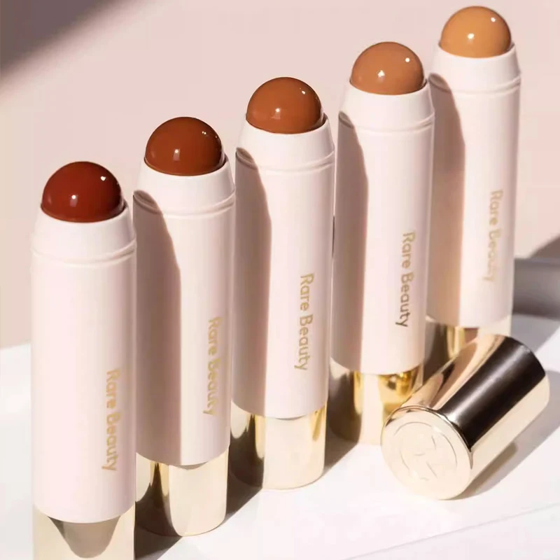 ไฮไลท์เตอร์เนื้อลิควิด RARE BEAUTY Body Enlighten พร้อมกระจกในตัว ให้ประกายละเอียด เนื้อเนียนนุ่ม สี Happy Sol ใช้ได้ทั้งไฮไลท์และคอนทัวร์ ช่วยปรับรูปหน้า