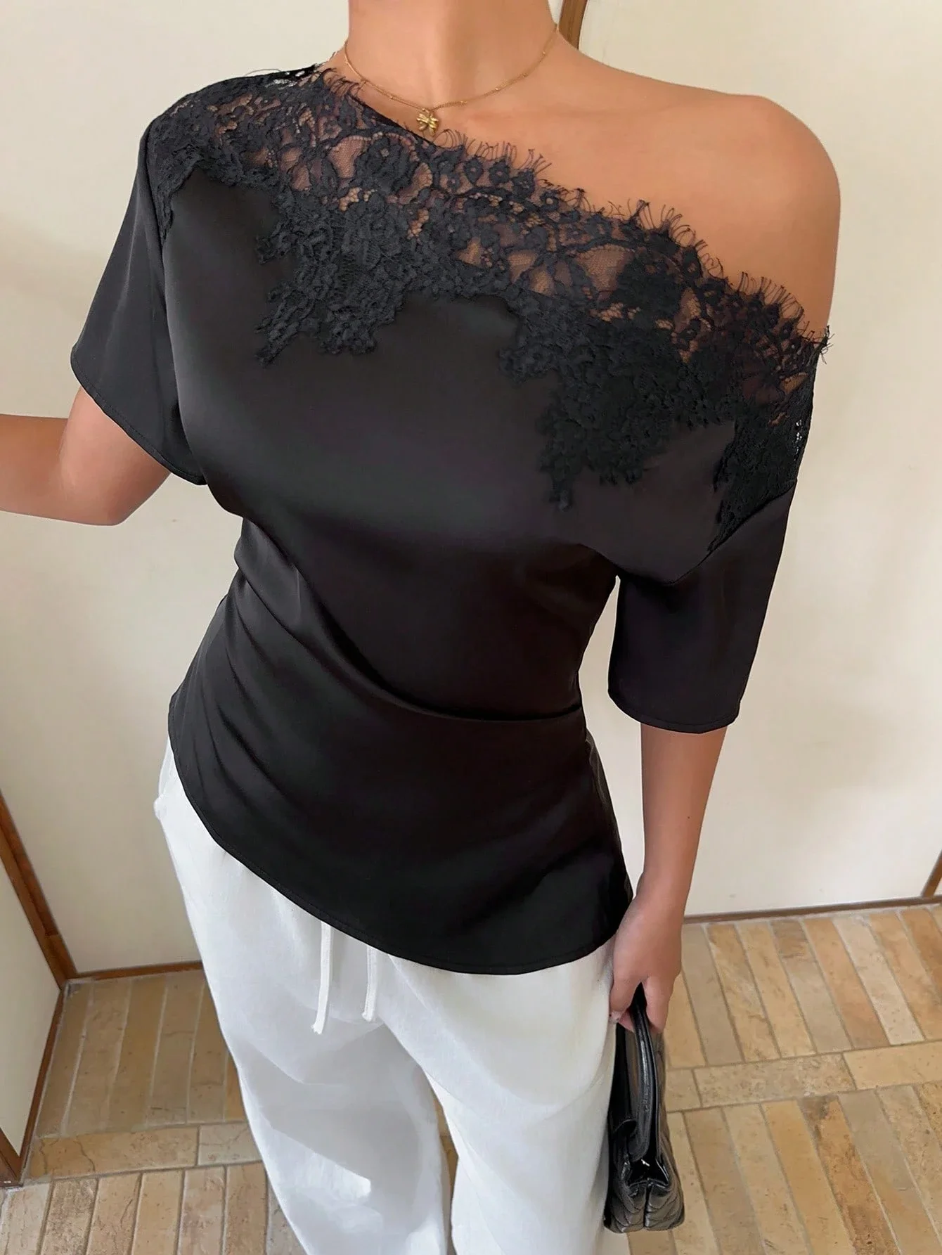 

Элегантный черный атласный топ с асимметричной кружевной отделкой на плечах и короткими рукавами