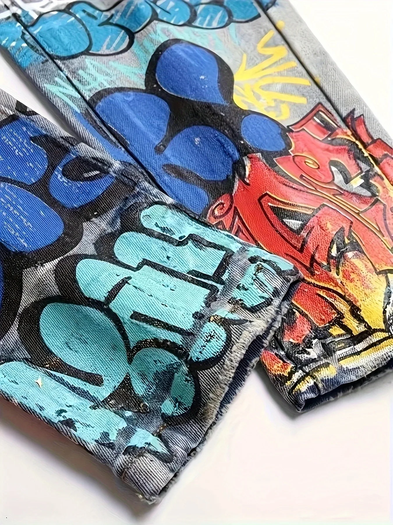 Vecchi jeans lavati e strappati con graffiti stampati europei e americani
