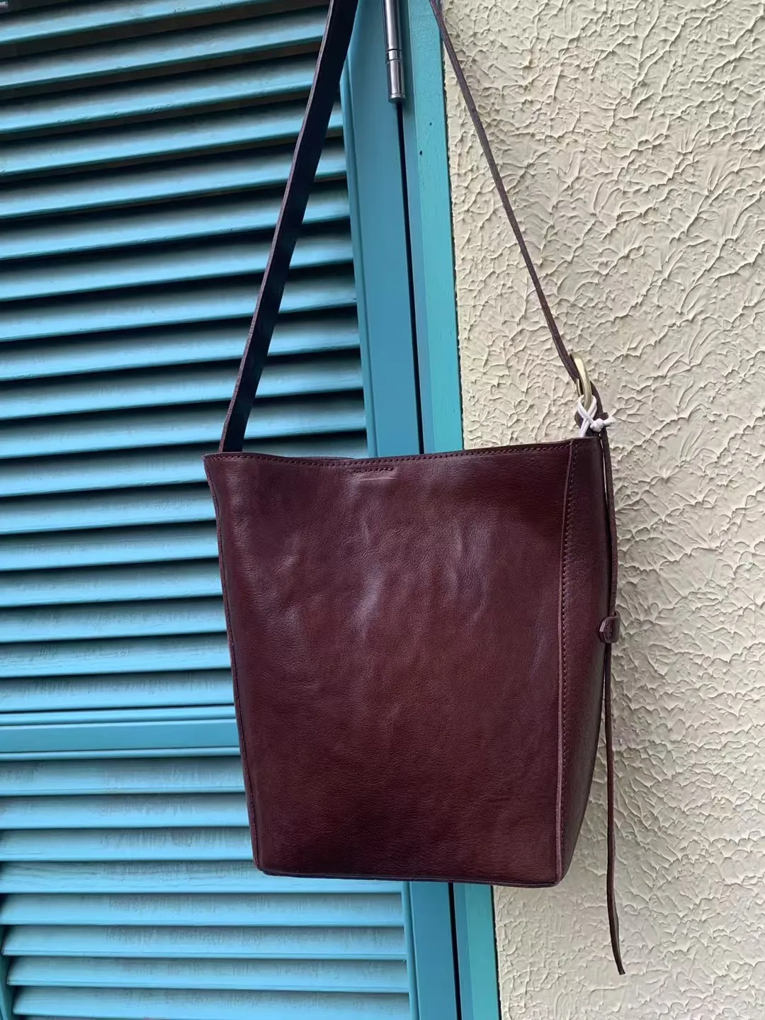 حقيبة كروس من جلد البقر المدبوغ بالزيت الثقيل المستورد، قهوة سوداء، أنجورا حمراء