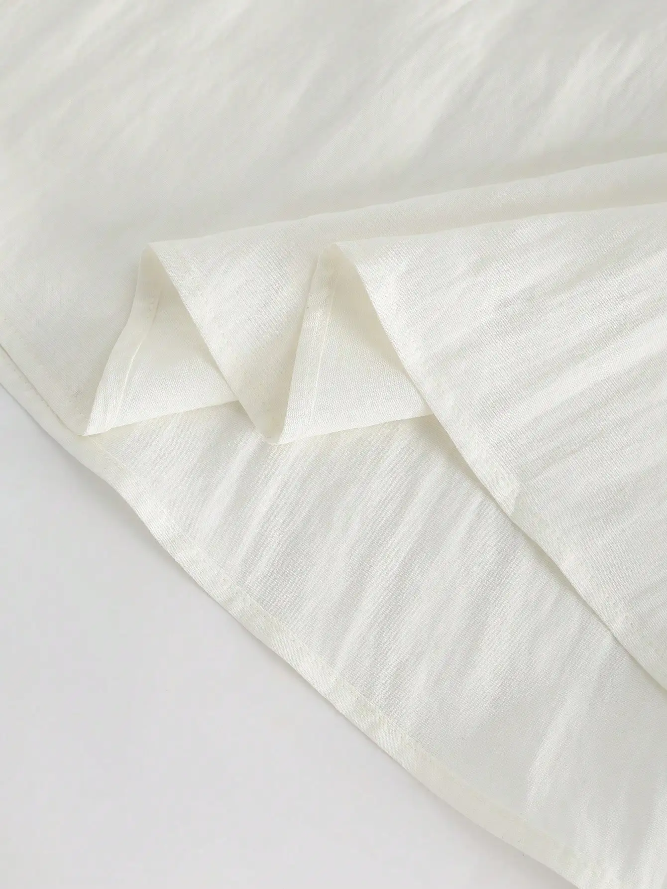 

Женский летний комплект из двух предметов: черный топ на тонких бретелях и белая плиссированная юбка с пуговицами спереди