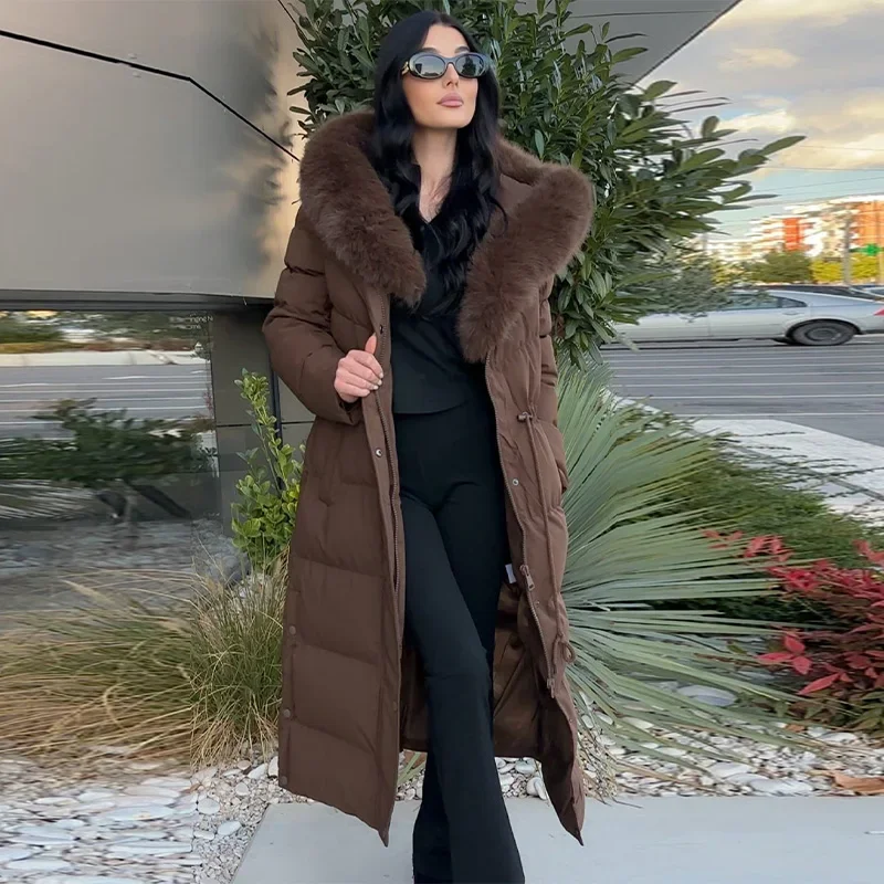 Un classico cappotto da donna lungo, spesso e caldo con colletto in lana, una elegante giacca con cappuccio in cotone e una vita aderente.