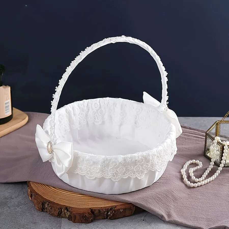 A floral basket with wedding candies, scattering flowers, and a beautiful large bow for the white flower girl.