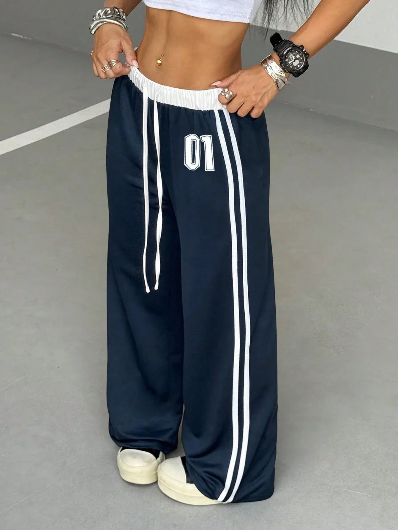 

Женские спортивные брюки с широкими штанинами, завязками на талии, боковыми полосками и принтом с номерами