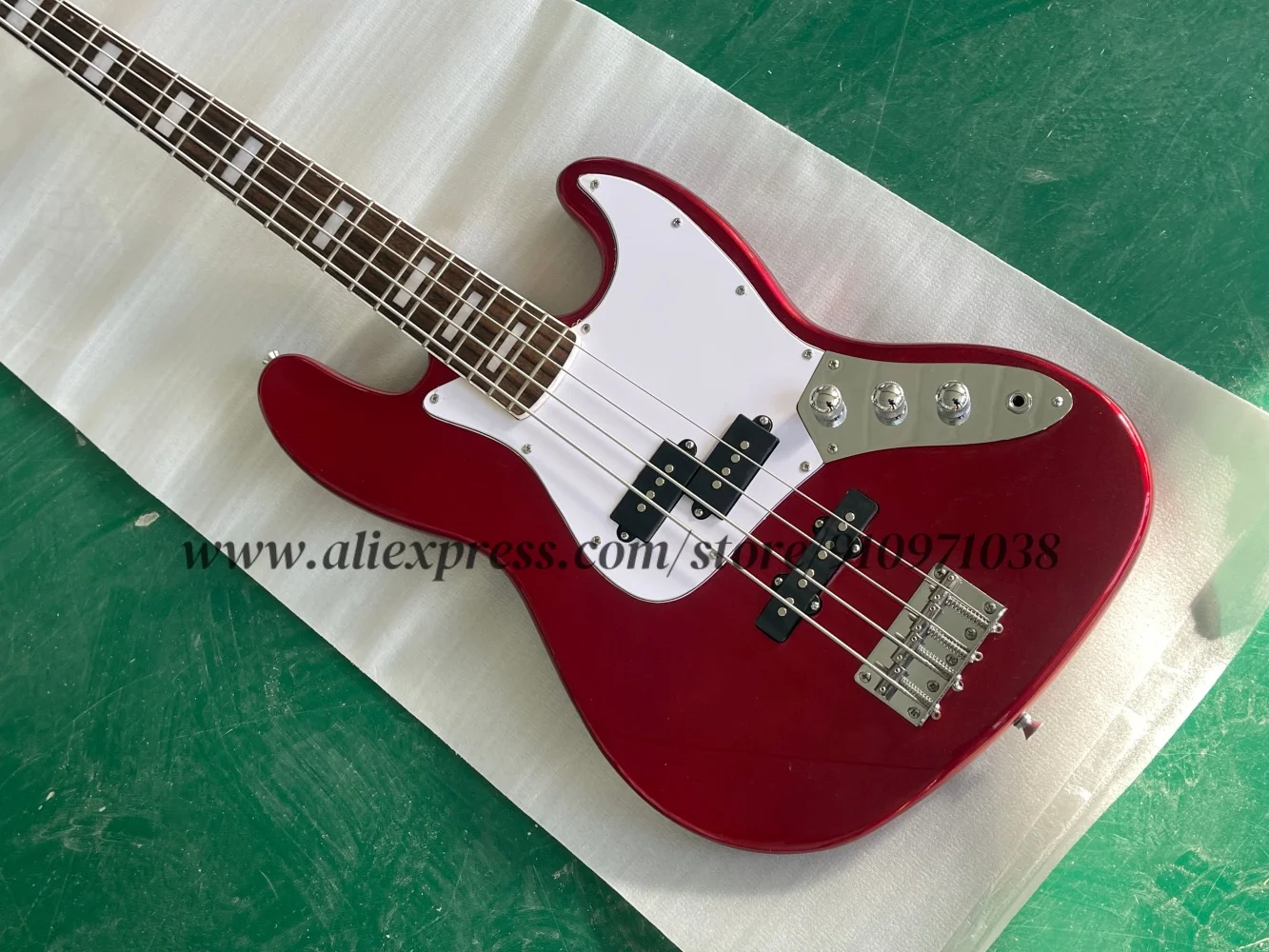 4 string guitar, metallic red bass guitar, fixed bridge, white guard plate, 3 pickups, solid wood body, rosewood fretboard