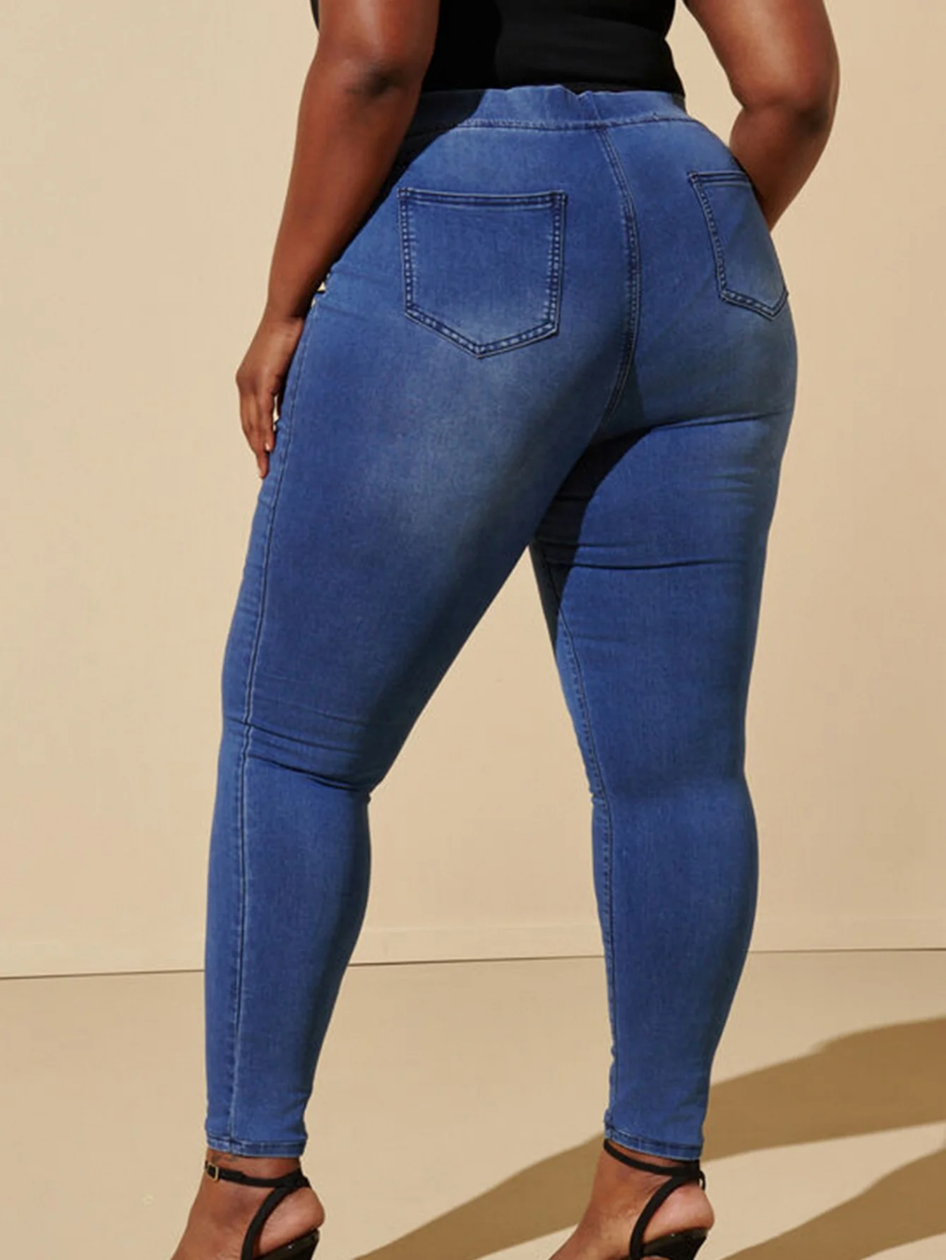 Dżinsy plus size, codzienne, elastyczne, z niebieskiego denimu, z gumką w pasie, o długości cropped, odpowiednie dla kobiet w okresie wakacji.