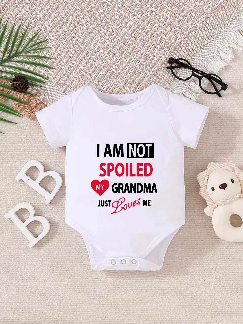 Playful letter-printed baby short-sleeve triangle bodysuit. Button closure for easy dressing, machine washable