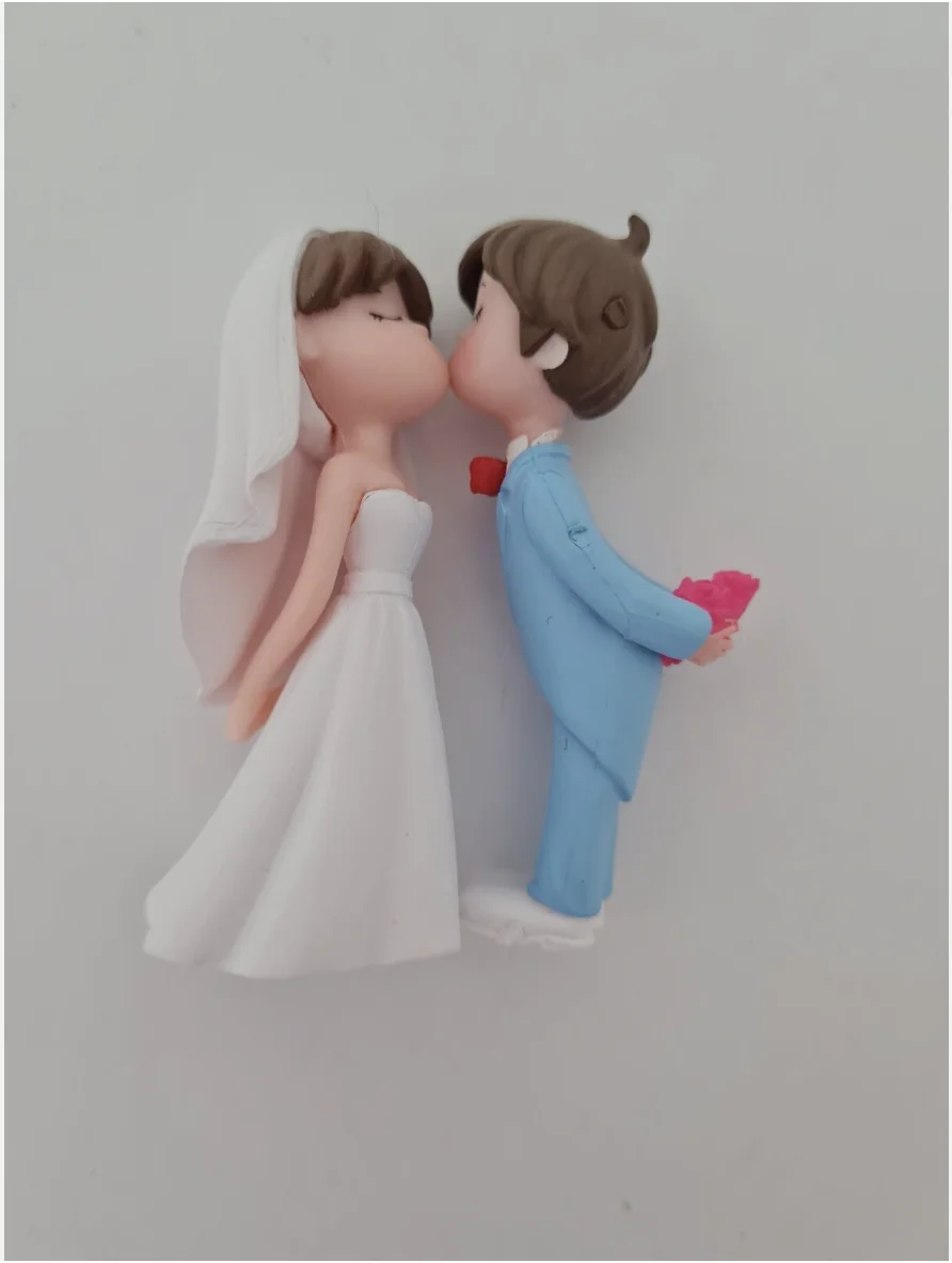 

Cute bride and groom kissing wedding cake topper