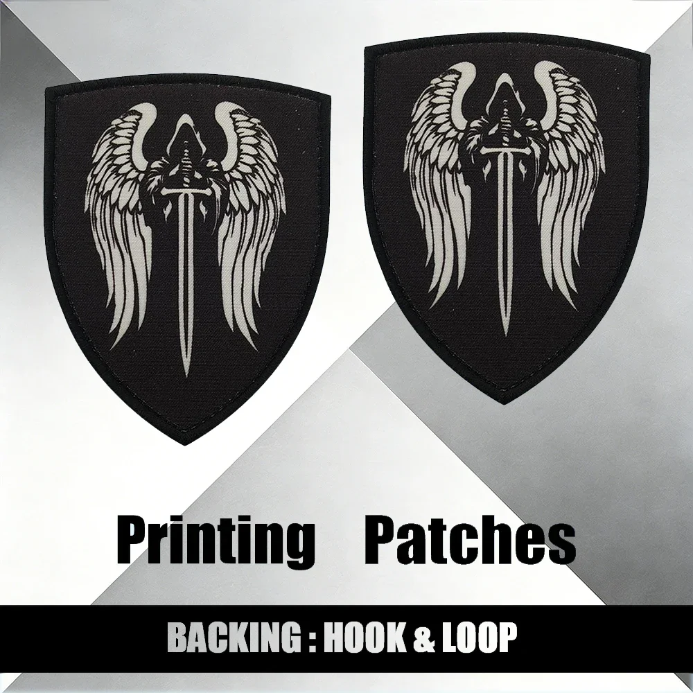 

Геральдический нашивной значок: Серебряный длинный меч с крыльями на черном щитке, с креплением на липучке, вышитый, для одежды и аксессуаров