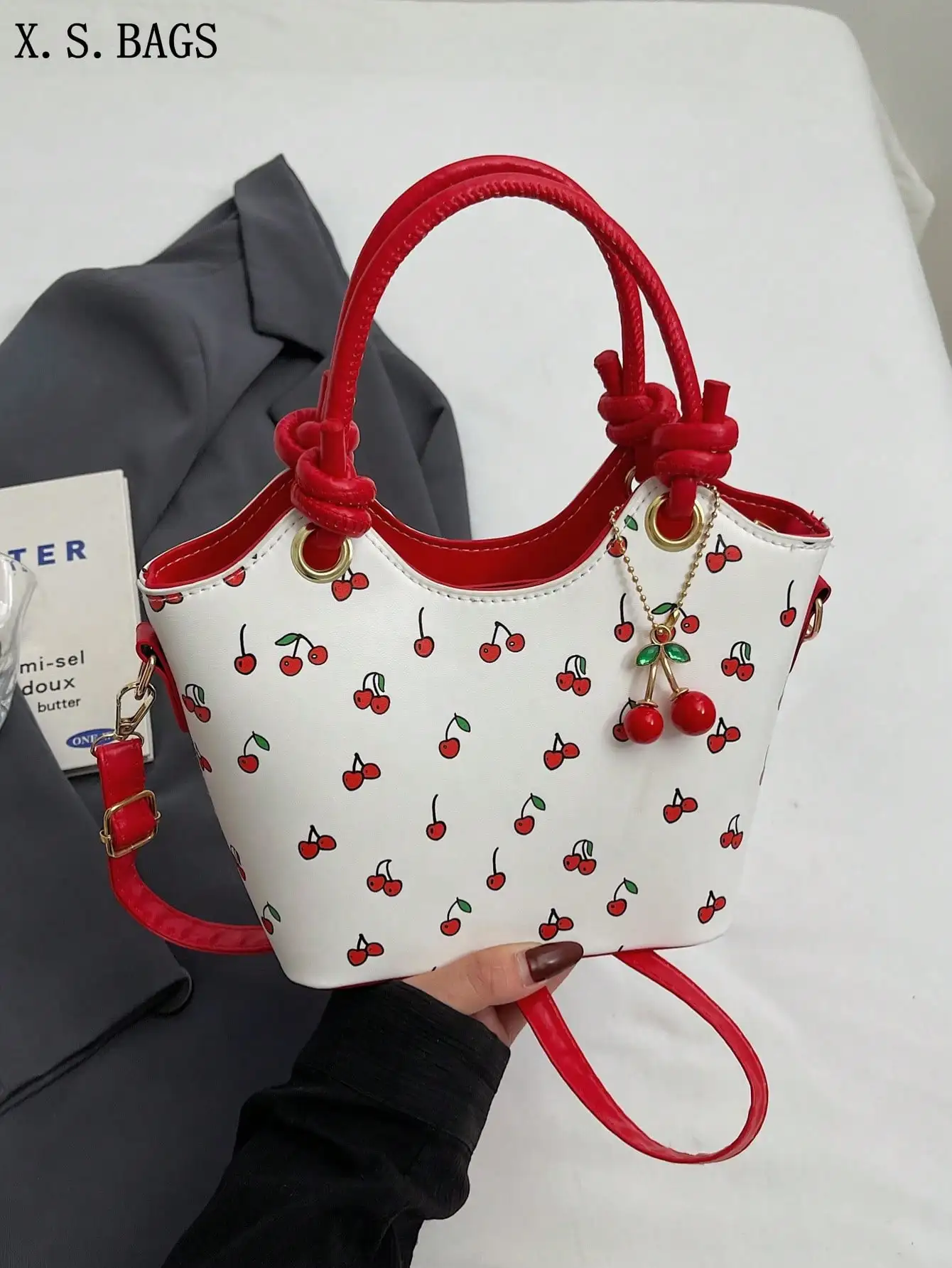 

Мини-сумка-ведро с вишнёвым принтом, красными узловыми ручками и подвеской