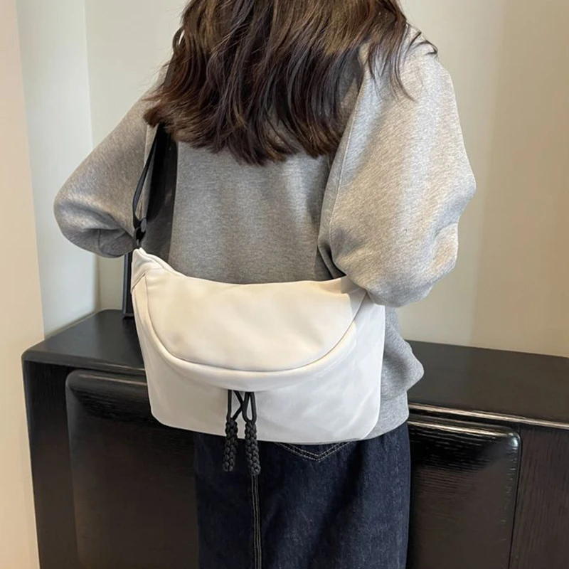 Quadratische Umhängetasche in neutraler Farbe für Damen und Herren, mit schlichtem Design, geeignet zum Tragen auf Reisen oder für den Arbeitsgebrauch.