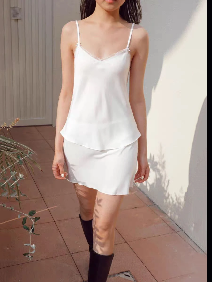 

Белый летний пижамный комплект с кружевной отделкой: топ на бретельках с V-образным вырезом и мини-юбка с низкой талией и бантом. Женский повседневный домашний прозрачный комплект из 2 предметов.