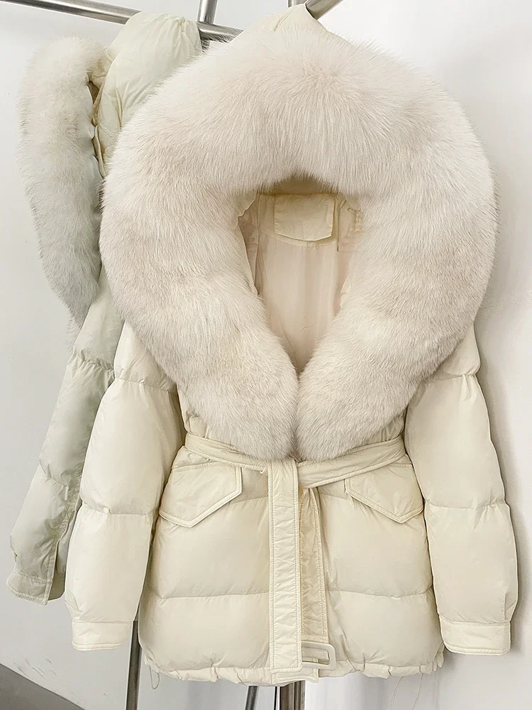جديد 2025 سترات نسائية فضفاضة دافئة بقلنسوة مع حزام سميك دافئ متوسط الطول معطف منتفخ بياقة من فرو الثعلب الحقيقي معطف أبيض مبطن للأسفل