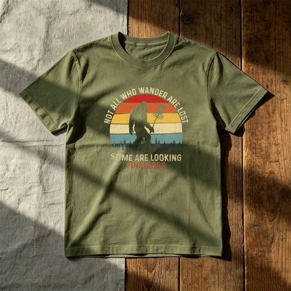 NOT ALL WHO WANDER ARE LOST SOME ARE LOOKING FOR DISCS Men T‑Shirt Bigfoot Disc Golf Retro Sunset Funny Outdoor Sport Fall Tee