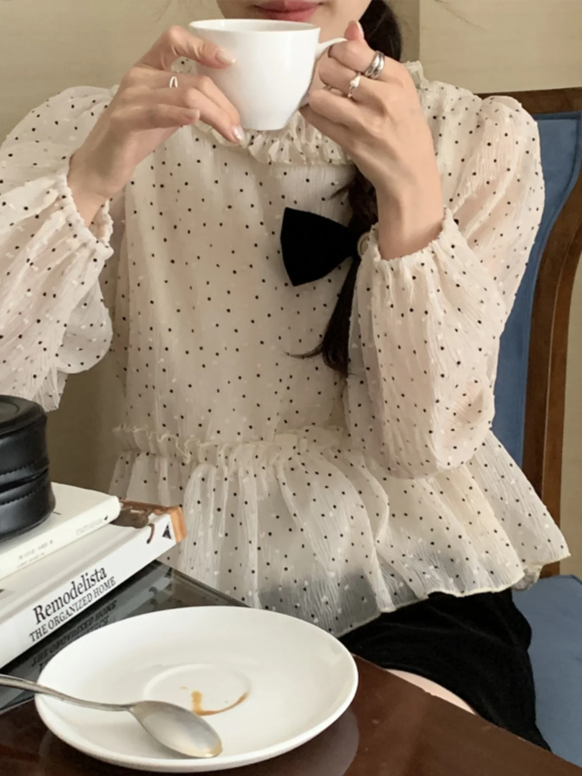 Csa e de bolinhas com manga bufante, csa fena curta e longa com cintura apertada e borda de ão de madeira,...