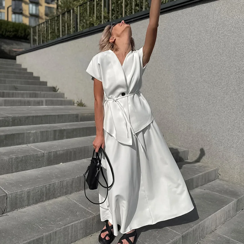 

Модный белый комплект из 2 предметов 2026 года: элегантный топ с V-образным вырезом и поясом, длинная юбка макси. Роскошные летние комплекты для отпуска.