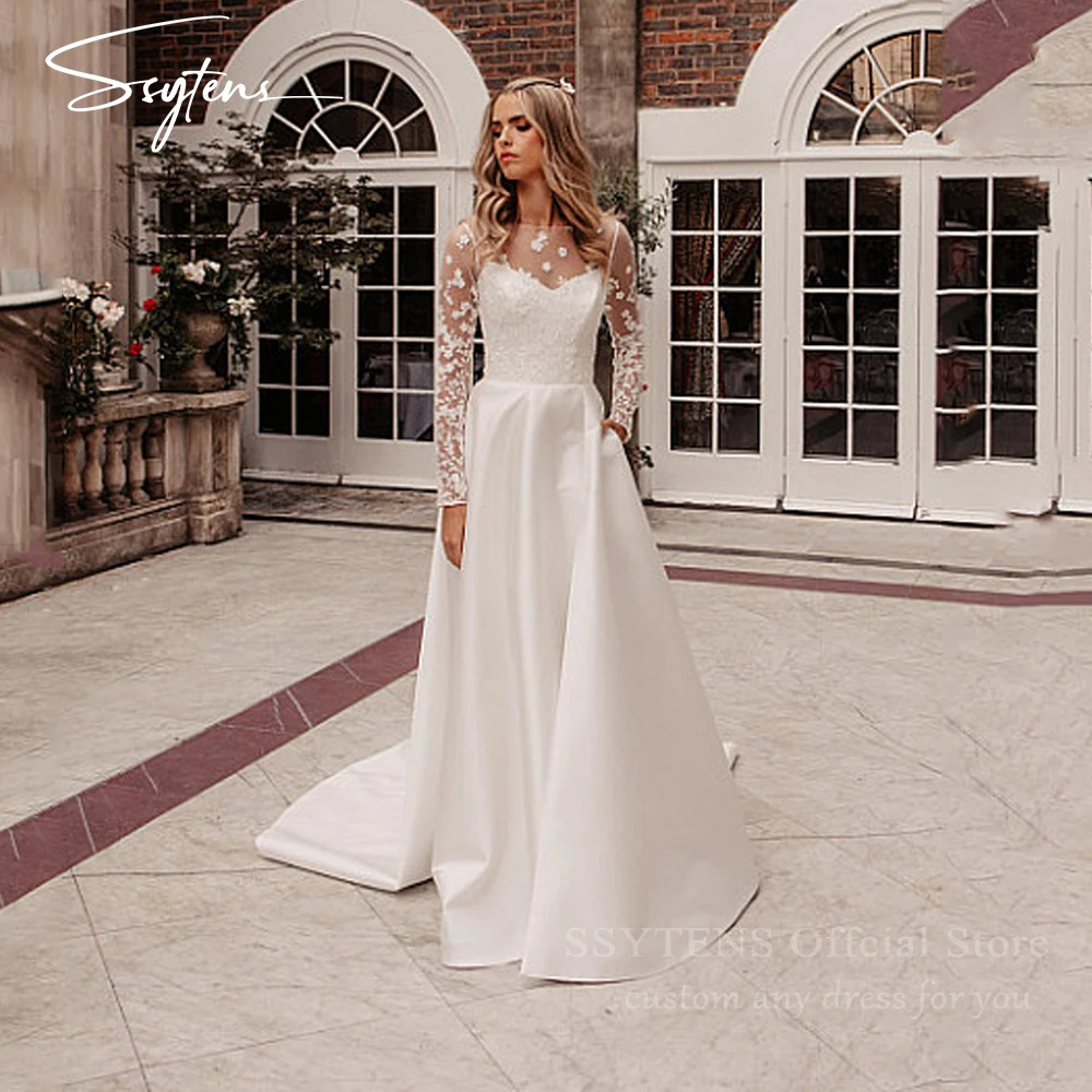 ชุดแต่งงานทรงเอไลน์สุดหรูจาก SSYTENS สีขาว ประดับด้วยลูกไม้ แขนยาวแบบซีทรู  ชุดเจ้าสาวแบบคอร์เซ็ทสั่งตัดได้ ปี 2026