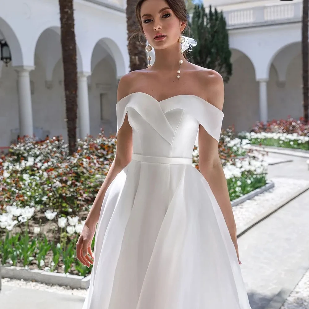 Vestido de novia elegante con hombros descubiertos, falda acampanada de satén con abertura alta, plisado en el busto, blanco marfil, sin mangas, 2023