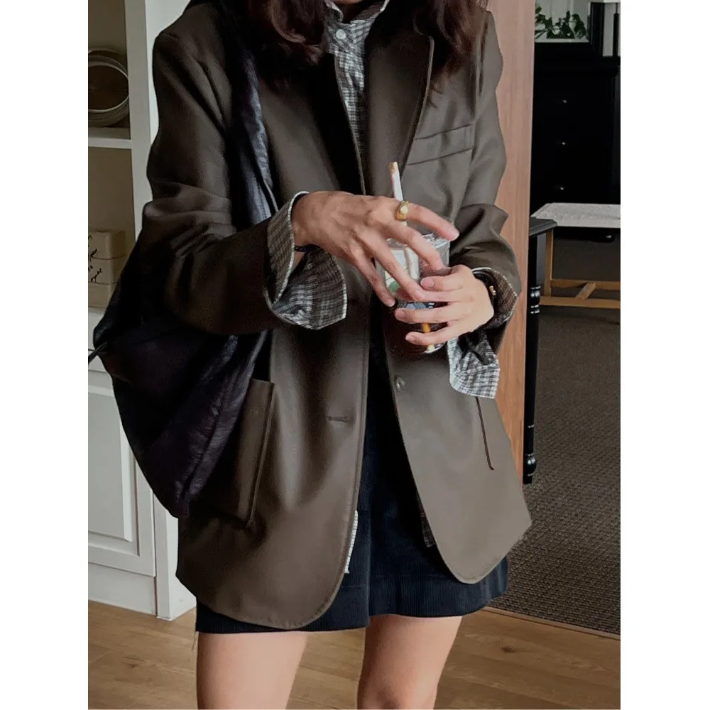 Długi płaszcz ze skóry PU z luźnym krojem i kołnierzem garniturowym, modna odzież wierzchnia dla młodych kobiet na sezon jesienny.