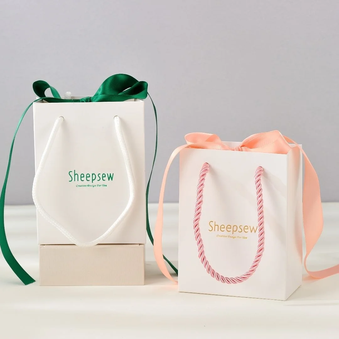 

Белые бумажные пакеты с атласной лентой и вашим логотипом. Персонализированная подарочная сумка с ручками для деловых презентаций. Вечеринка. Покупки оптом.