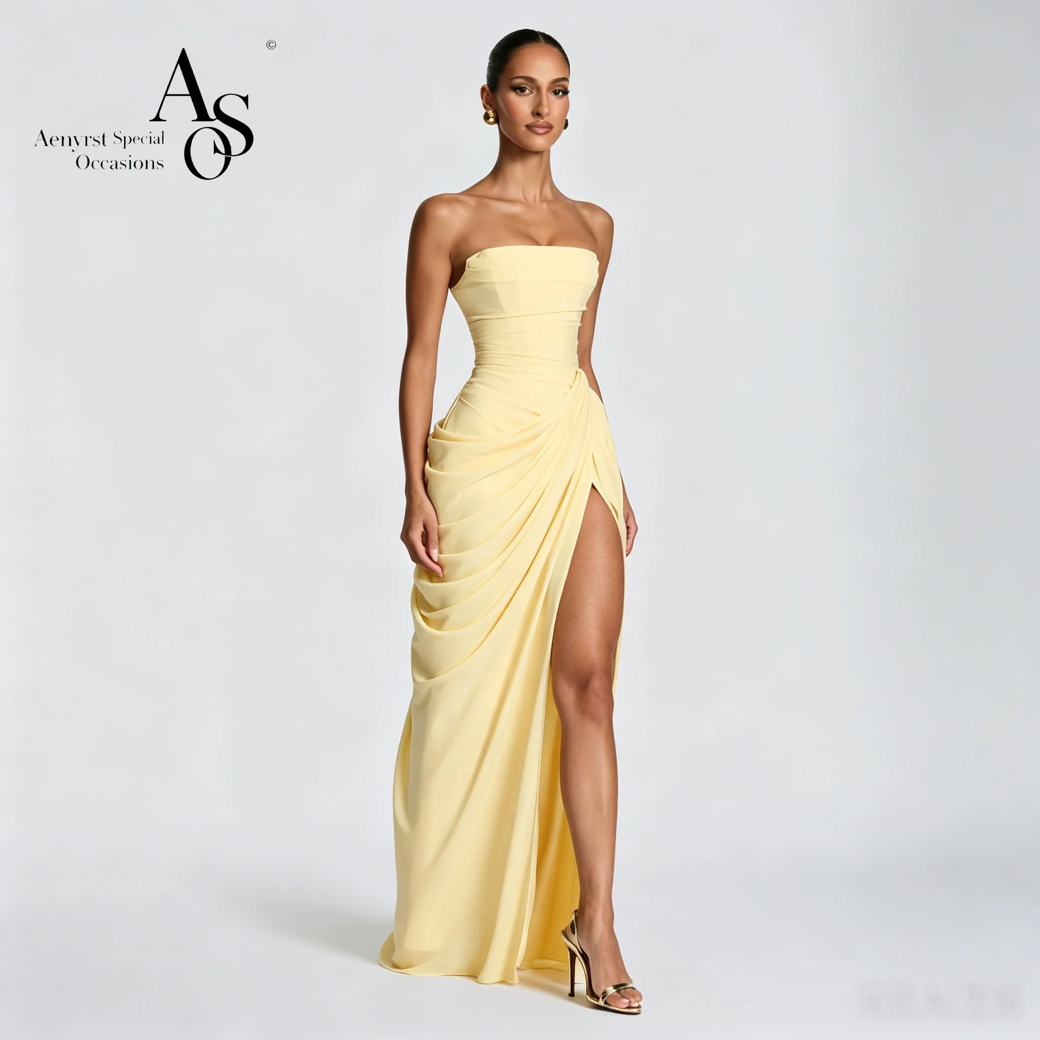 Elegant yellow strapless sleeveless floor-length mermaid gown for formal occasions featuring ruching and a slit skirt