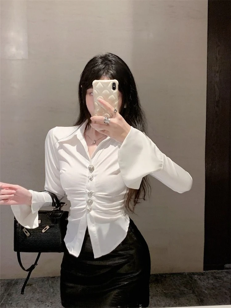 Elegancka damska bluzka z nieregularnym podkreśleniem talii, długim rękawem, z miękkiego, połyskującego materiału, jesienna moda, biała, casualowa, szykowna góra. ​