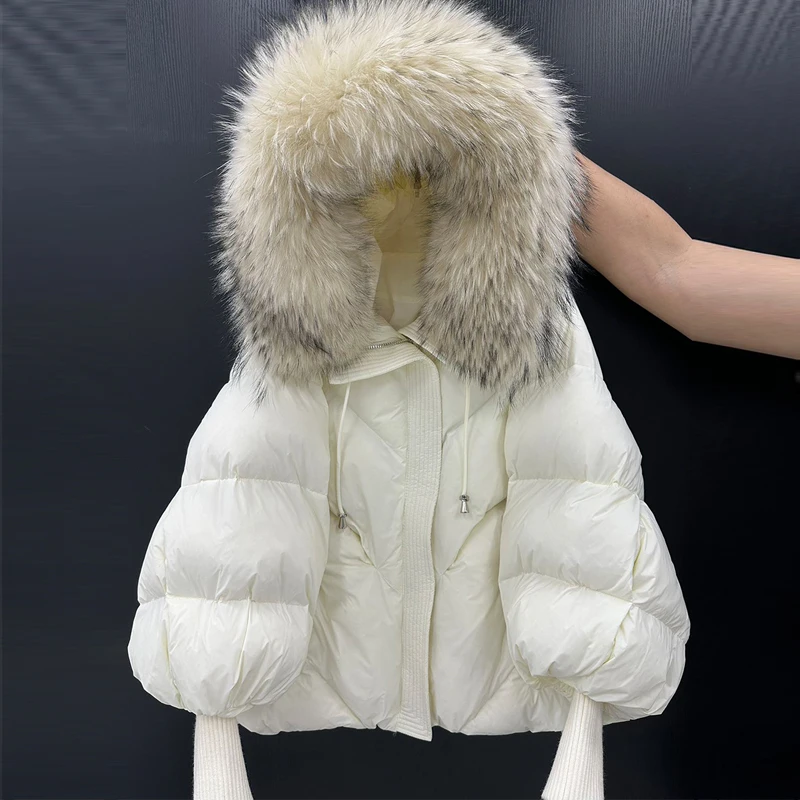 เสื้อโค้ทไหมพรมถักแบบมีฮู้ดสำหรับผู้หญิง ความยาวปานกลาง แต่งปกขนเฟอร์ขนาดใหญ่ อุ่นสบาย สไตล์ลำลอง สีขาว ขนนก