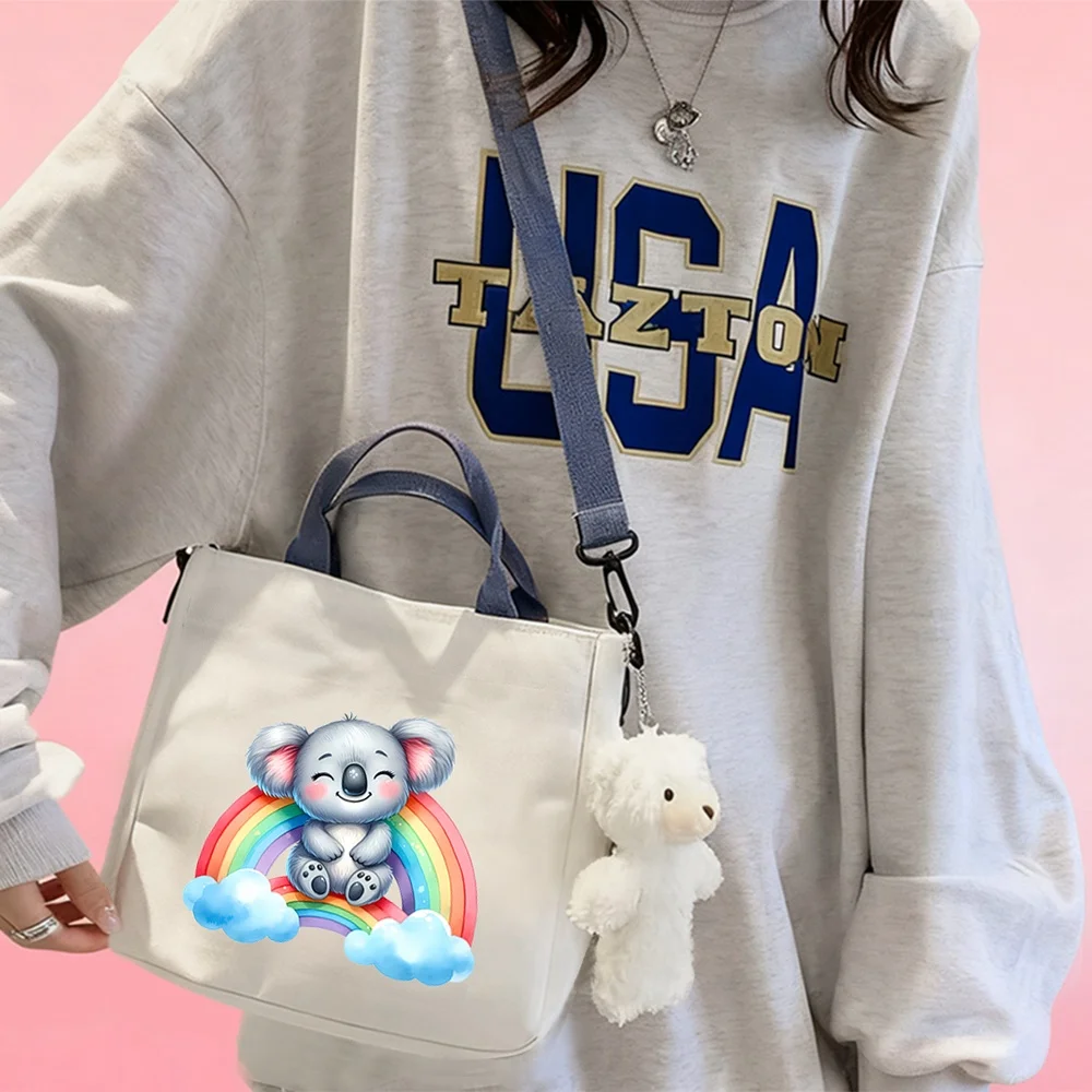 Handbags and crossbody bags featuring a koala-on-a-rainbow design, perfect for travel and organizing cosmetics.