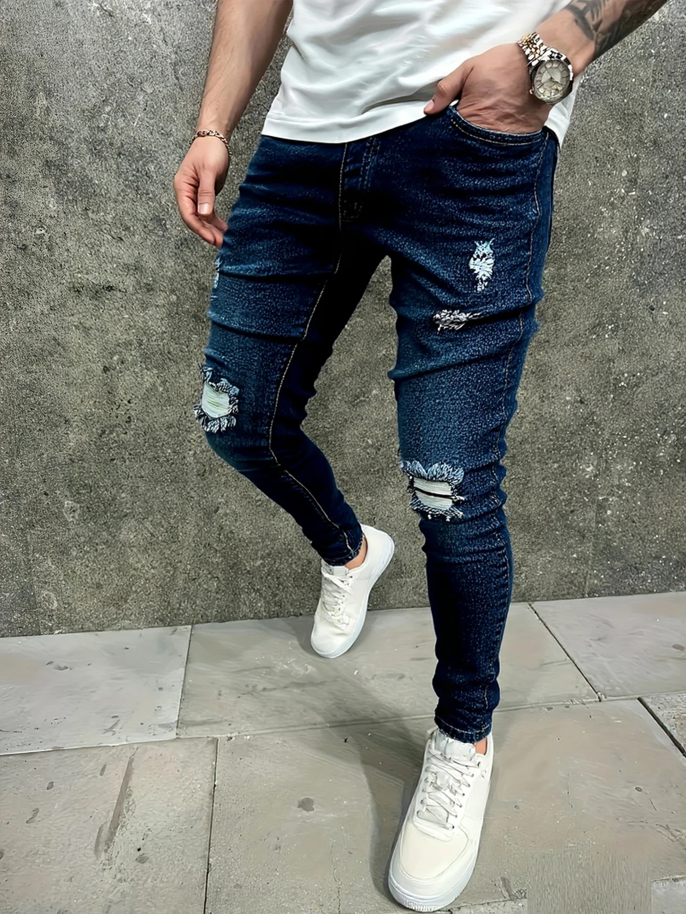 メンズのブルーのダメージ加工スキニージーンズ。膝やその他の部分にヴィンテージ風のリップ加工が施され、体にぴったりフィットするデザインです。