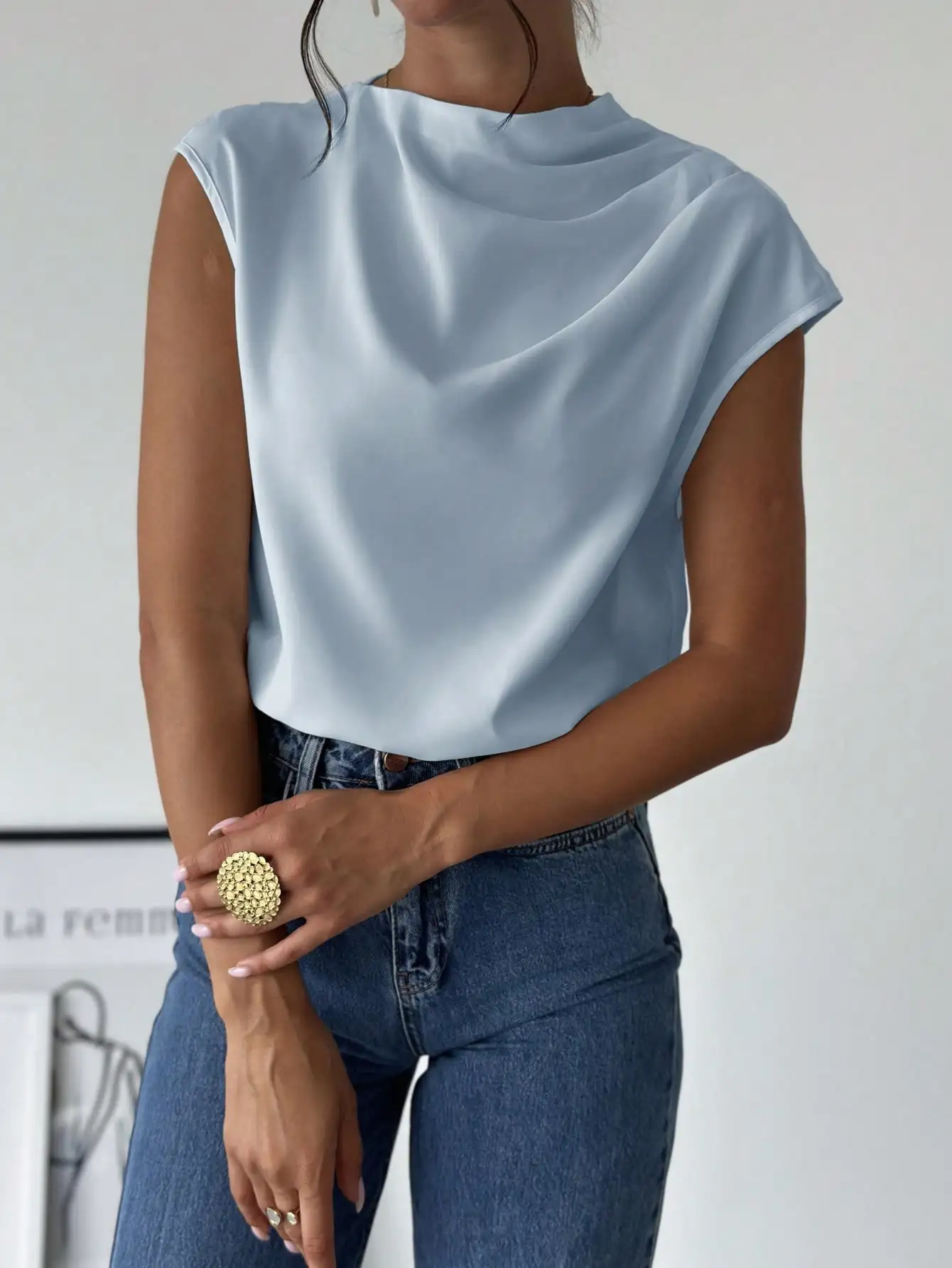 

Женская блузка светло-голубого цвета с асимметричным плечом, плиссировкой и воротником-стойкой