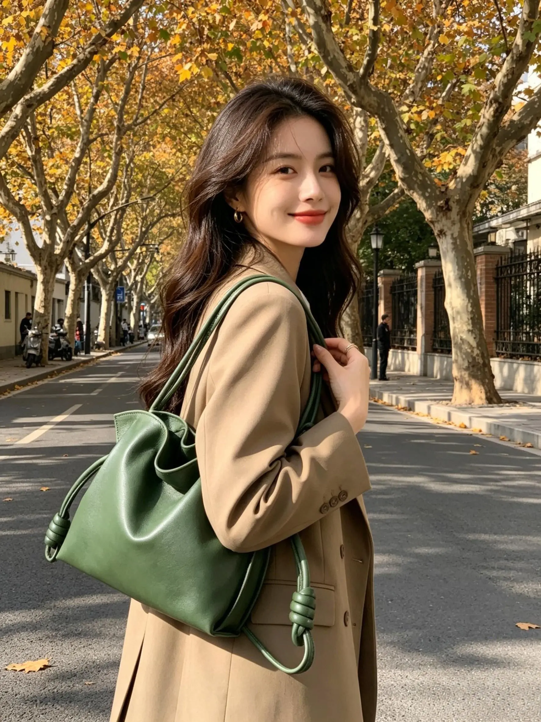 

Forest green genuine leather drawstring bucket shoulder bag with knotted leather drawstring details and double wide shoulder straps.
