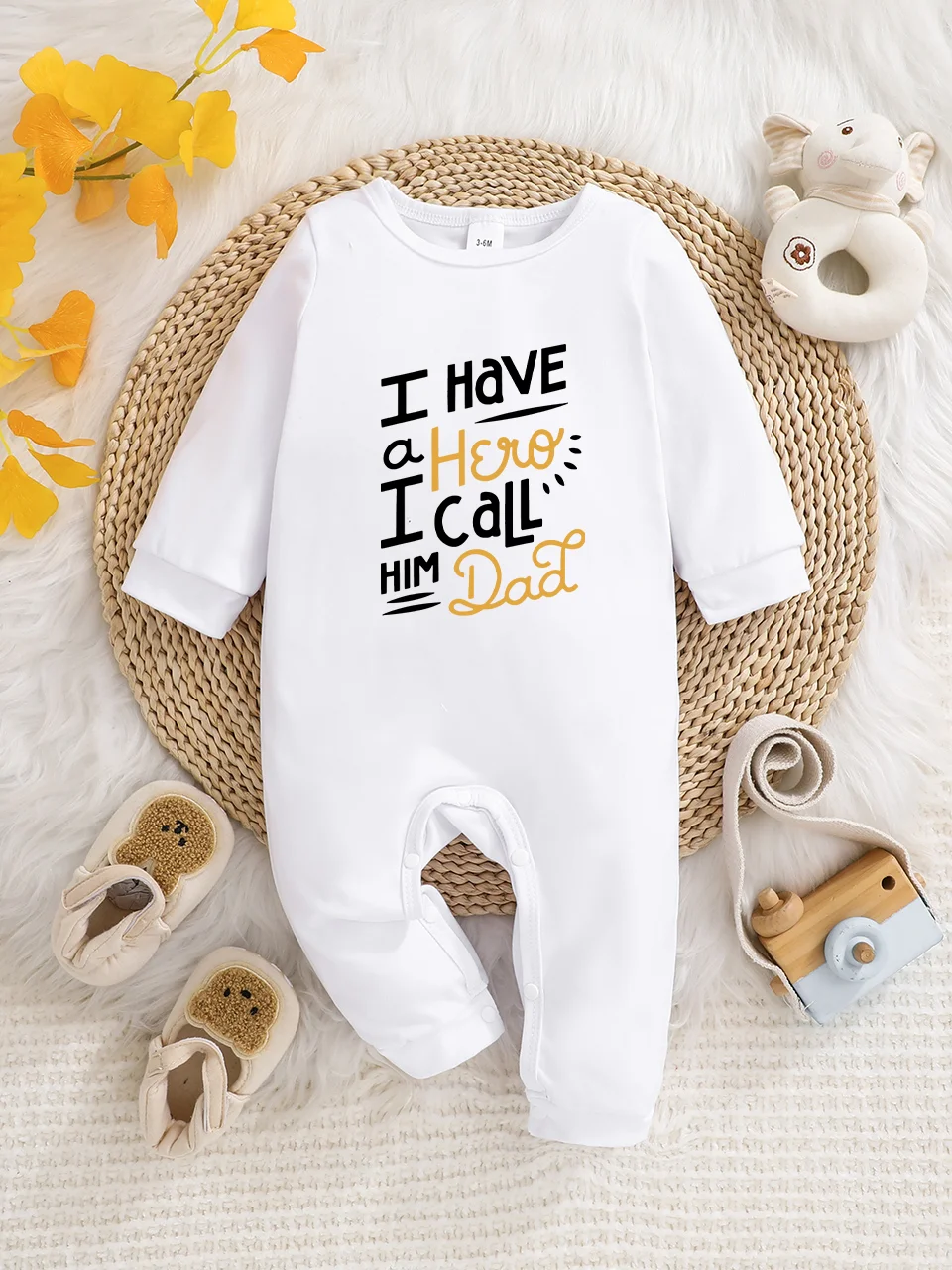 Ein langärmeliger Baby-Strampler mit interessanten Buchstaben-Prints. Es verfügt über ein Knopfverschluss-Design für einfaches An- und Ausziehen, und