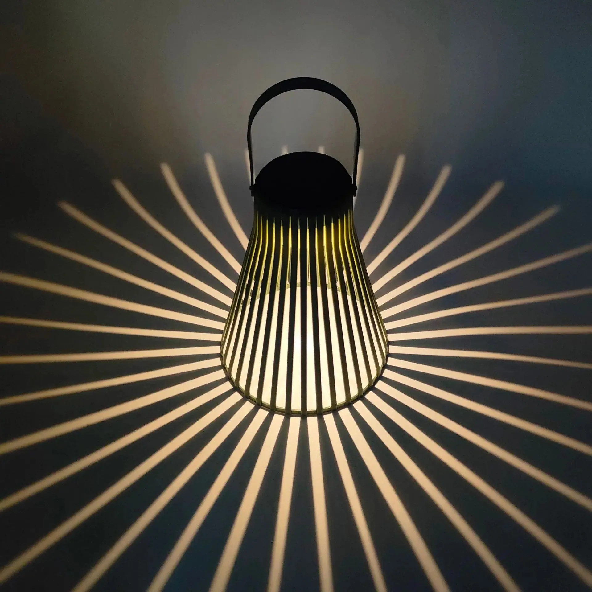 SoraWeave solar rattan hanging lights lit up in orange and warm yellow hues