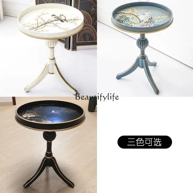 **โต๊ะกลมเล็กทาสีมือสไตล์อเมริกันในชนบท โซฟาไม่กี่มุมในห้องนั่งเล่น และโต๊ะกลมไม่กี่ตัว