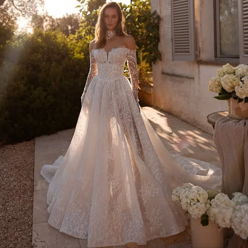 Błyszczące białe suknie ślubne z aplikacjami, odkryte ramiona, spódnica w kształcie litery A, brokatowe zdobienia, długie rękawy, suknie ślubne szyte na miarę.