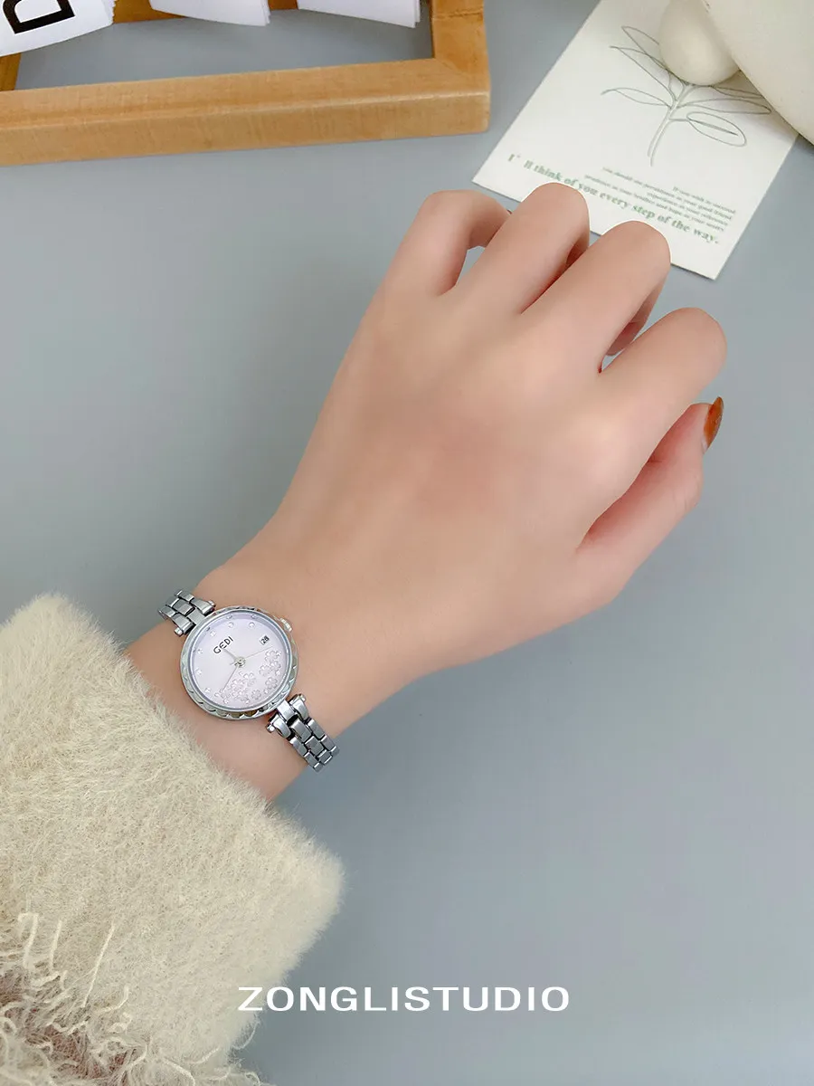 นาฬิกาข้อมือผู้หญิงสายเหล็กดีไซน์หรูหราใหม่ ดีไซน์กะทัดรัด ทันสมัย และน่าดึงดูดใจ นาฬิกาควอตซ์เรียบง่ายสำหรับนักเรียน พร้อมลวดลายดอกไม้