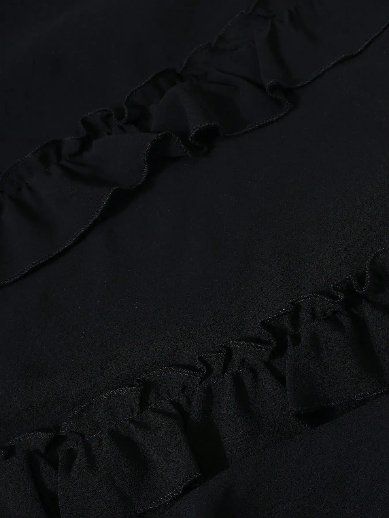 Um vestido preto até o chão com macarrão fino e pregas em camadas – um vestido de festa elegante e fluido com alças finas