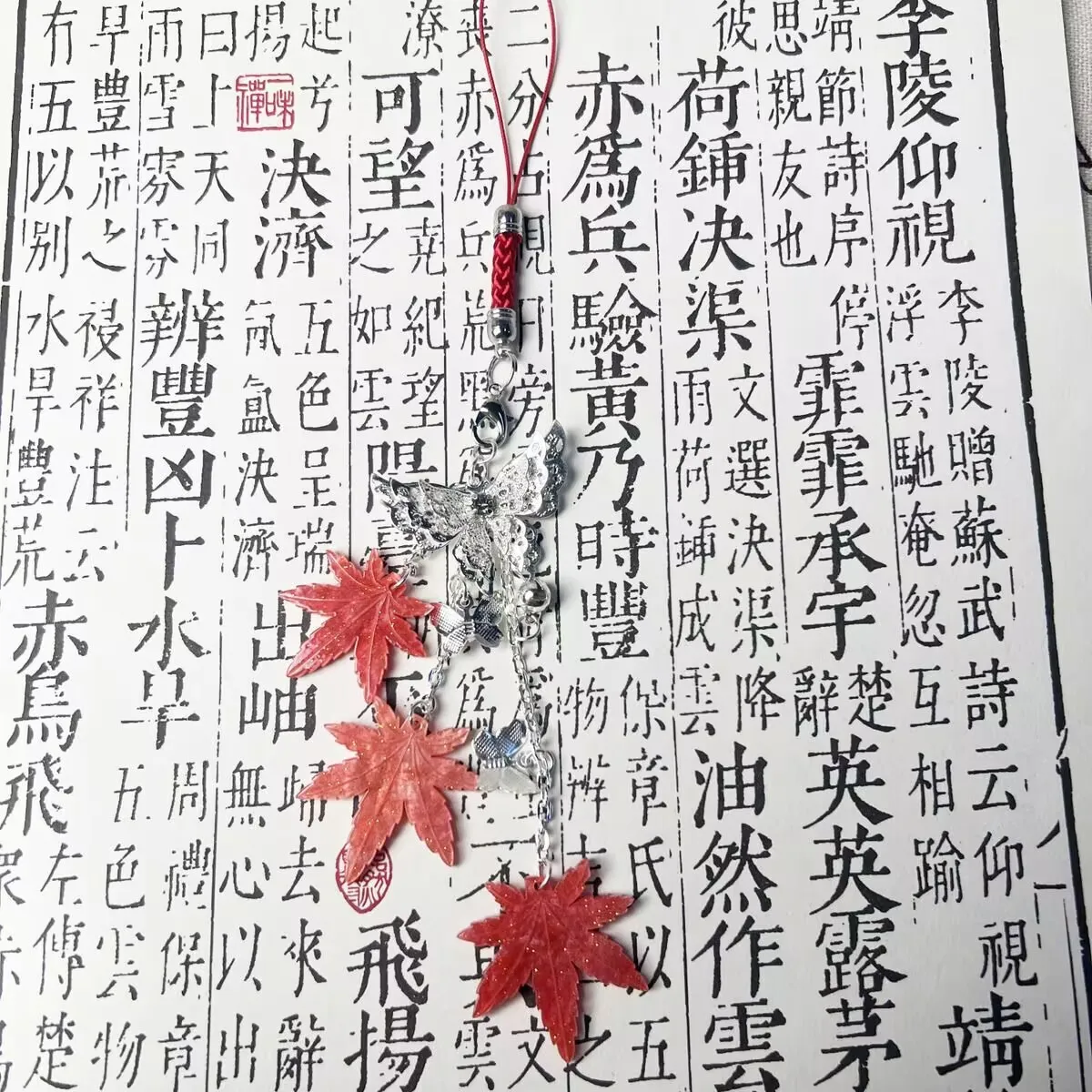 เทพธิดาสวรรค์ทรงพระราชากรุณาบุญคุณให้กับชาวเมืองดอกไม้ เซียเหลียน ด้วยเครื่องประดับรูปใบเมเปิ้ล กระดิ่ง และผีเสื้อสำหรับติดโทรศัพท์มือถือ