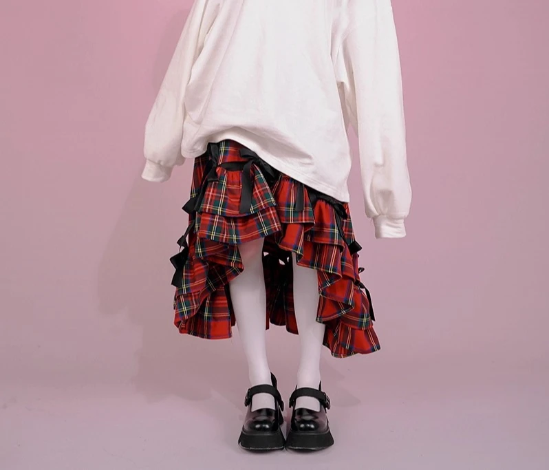 Gonna lunga versatile carina retrò in vita elastica con fiocco dolce irregolare Primavera Estate Nuove gonne per ragazze con volant scozzesi rossi che riducono l'età