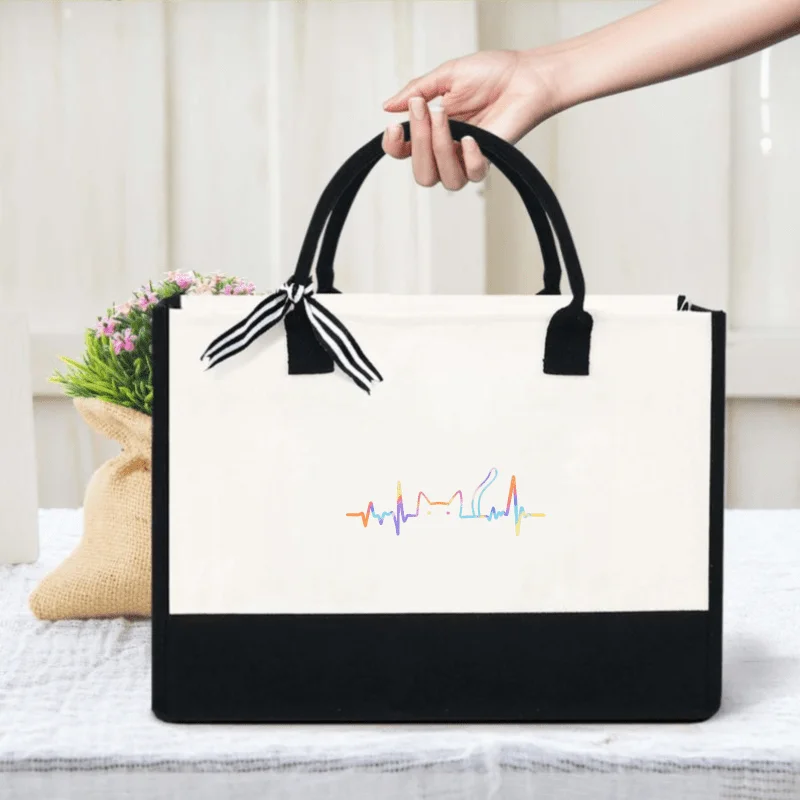 White and black canvas handbag with rainbow heartbeat pattern, suitable for daily use