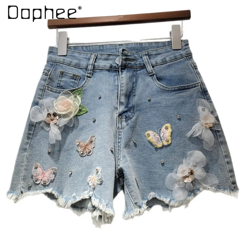 Pantaloncini di jeans personalizzati della stazione europea Donna 2025 Estate Nuova tendenza Perline strappate Ricamo floreale Pantaloni slim a gamba larga Alla moda